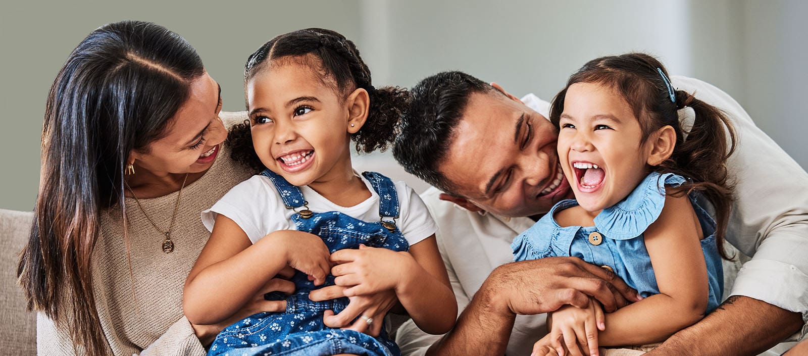 Love, care and parents with happy family of children laughing together at home in Puerto Rico. Mama, father and daughter siblings bonding in house with cheerful affection and excited smile