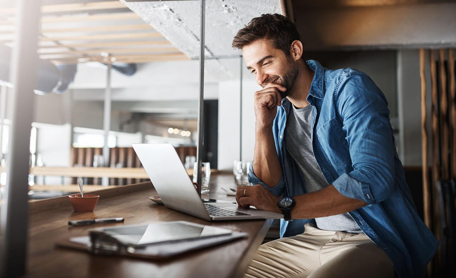 Man in coffee shop, laptop and small business owner, entrepreneur in hospitality management and connectivity. Happy male professional, cafe franchise and wireless connection with digital admin on pc.